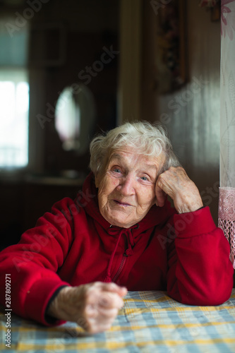 Portrait of emotional elderly woman in his home.
