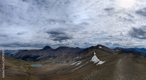 Hiking trail through a panoramic Rocky Mountain landscape with a white clouds  mountains and hills.