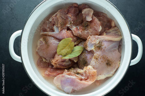 Raw chicken legs in pan, ready to coook. Top view over dark background. photo