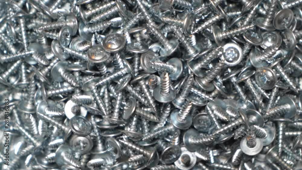 Sheet metal screw background. Pile of self-tapping screws rotation top view. Sheet metal screw background. Pile of self-tapping screws rotation top view.