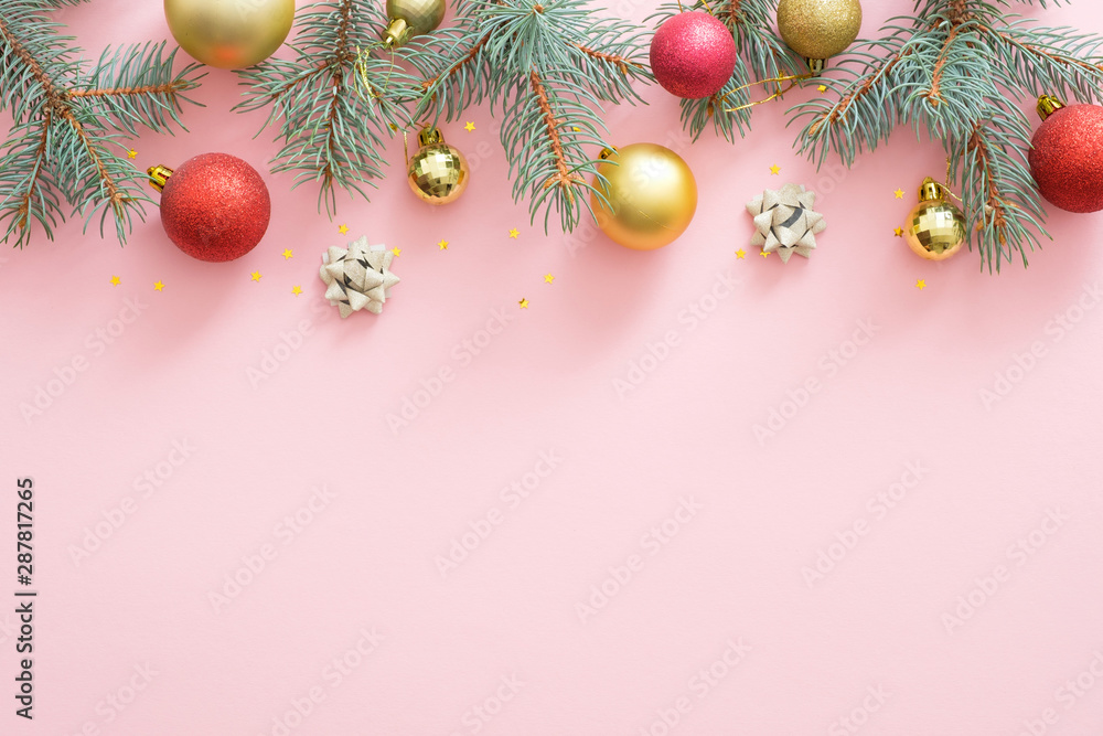 Christmas frame made of bright glittering baubles, fir tree branches, decorations on pink pastel background. Christmas party invitation card mockup, postcard template. Flat lay, top view, overhead