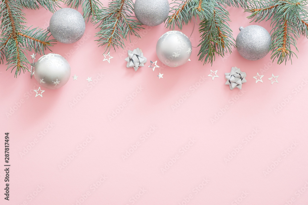 Christmas holiday composition. Christmas tree fir branches, silver balls on top border on pink pastel background with copy space. Flat lay, top view, Xmas glamour banner mockup, invitation card. Christmas holiday composition. Christmas tree fir branches, silver balls on top border on pink pastel background with copy space. Flat lay, top view, Xmas glamour banner mockup, invitation card.