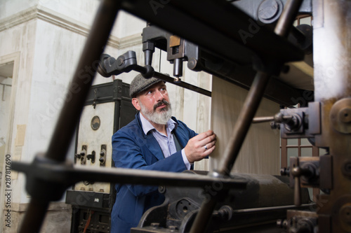 Mechanic working on a vintage printing press