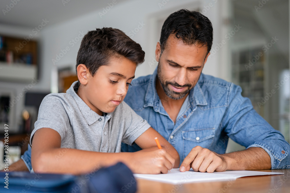 Father helping son doing homework Father helping son doing homework