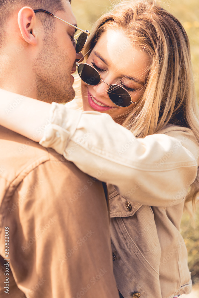 attractive woman hugging and kissing with handsome man in sunglasses attractive woman hugging and kissing with handsome man in sunglasses