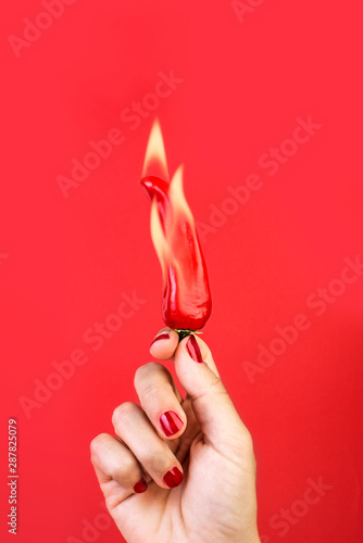 hand holds burning red pepper