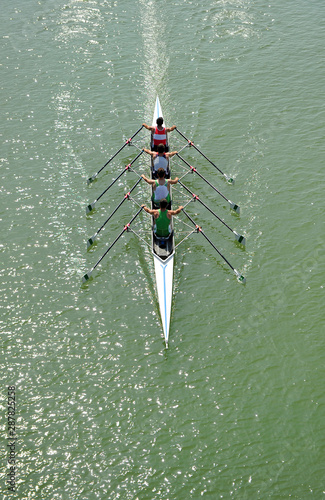 Nautical sports. Four men canoeing rowing up on a training session, Guadalquivir river in Seville, Andalusia, Spain