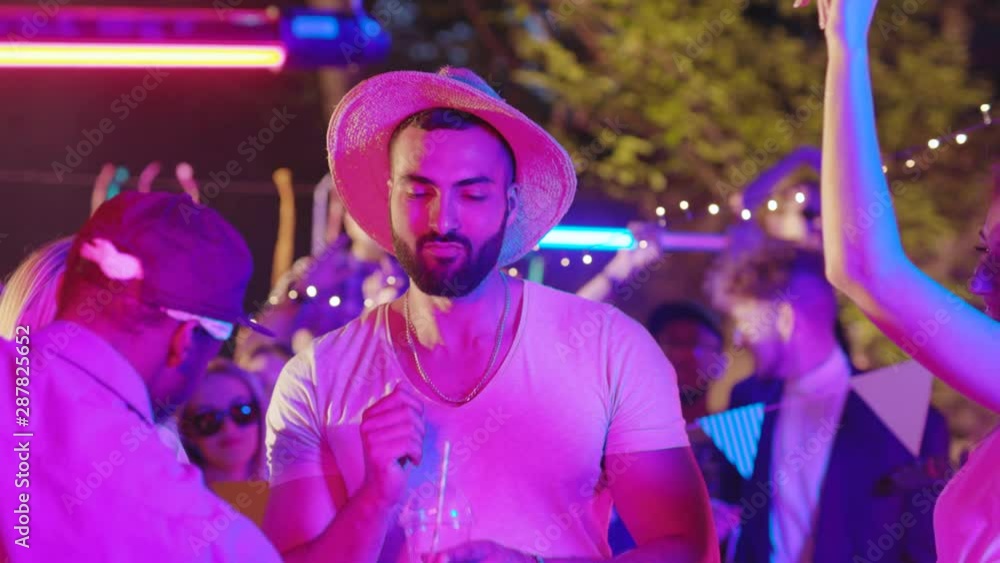Handsome caucasian guy and his multiethnic friends hanging out having fun jolly time together partying at night. Handsome caucasian guy and his multiethnic friends hanging out having fun jolly time together partying at night.