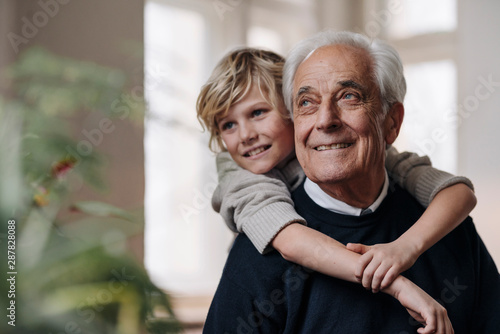 Happy grandson embracing grandfather at home photo