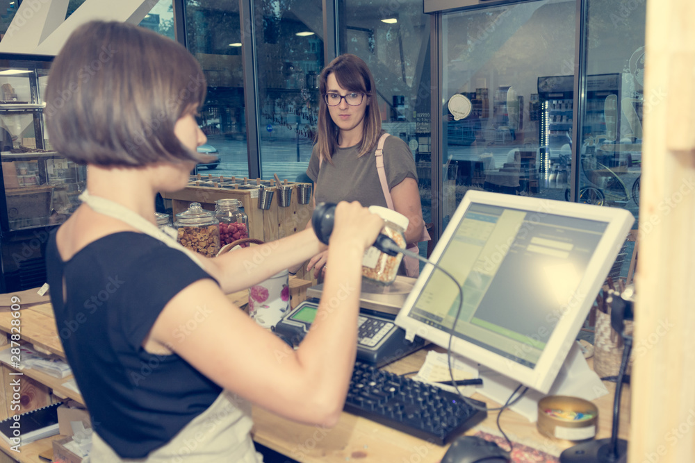 Female shop assistant serving a customer at a desk. Female shop assistant serving a customer at a desk.