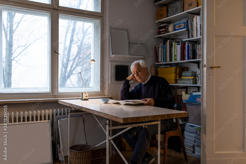 Senior man reading book at home Senior man reading book at home