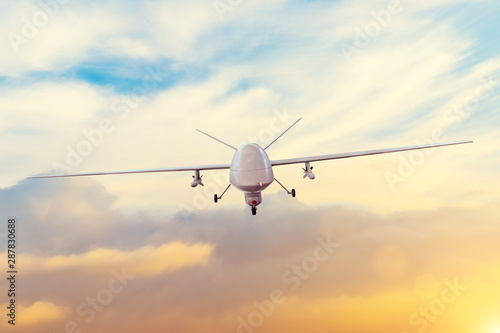 Unmanned military drone patrols the territory at sunset. The view is straight ahead.