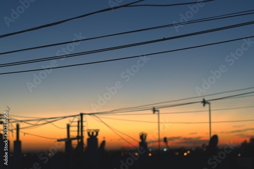 Telephone cables, chimneys and TV antennas silhouetted against the early morning sky just a few minutes before sunrise.