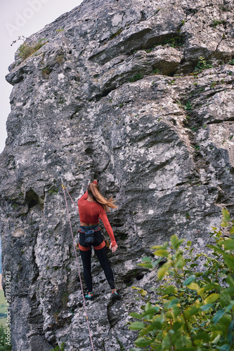 Young fit beautiful woman rock climbing in nature Slovakia