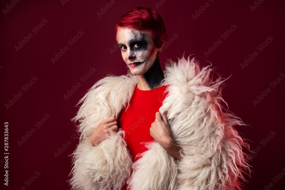 Female with scary clown makeup and red hair wearing white faux fur Female with scary clown makeup and red hair wearing white faux fur