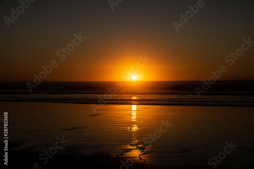 Last sunlight of the day with sunset over the Atlantic Ocean from Agadir beach, Morocco, Africa