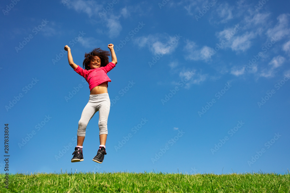 Happy curly hair girl jump over blue sky hands up Happy curly hair girl jump over blue sky hands up