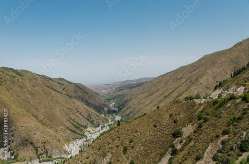 A mountain gorge in which a mountain river flows and a road passes. Location near Almaty, Kazakhstan