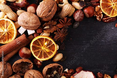 Composition with dried fruits and assorted healthy nuts on rustic background for christmas