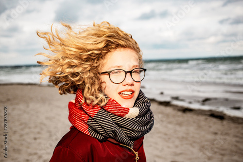 Curley blond girl at the beach while windy