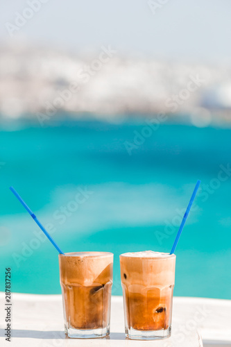 Coffee latte on wooden table with sea background
