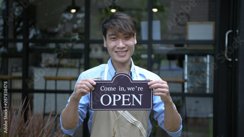 Coffee shop concept. The receptionist was holding a sign indicating that the coffee shop was opened.