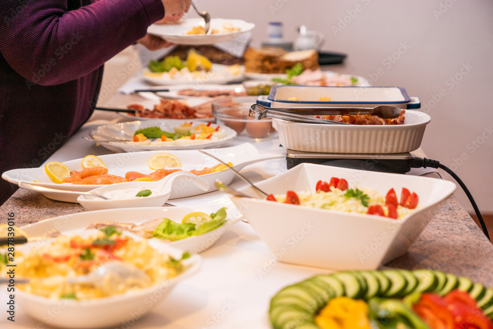 Frühstücksbuffet, Deutsches Frühstück, Menschen bedienen sich am Buffet, All-You-Can-Eat, gemütlich frühstücken, Buffet, kalte Speisen Frühstücksbuffet, Deutsches Frühstück, Menschen bedienen sich am Buffet, All-You-Can-Eat, gemütlich frühstücken, Buffet, kalte Speisen