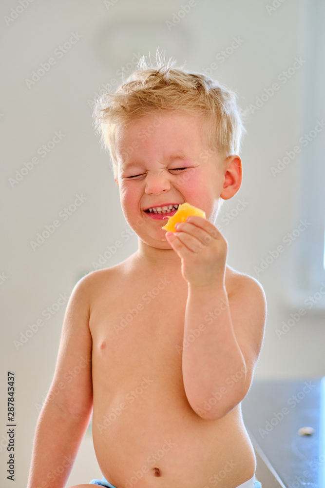 Two year old boy eating sour fruit Two year old boy eating sour fruit