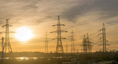 electricity pylons with cables going into the distance at dawn or dusk. 