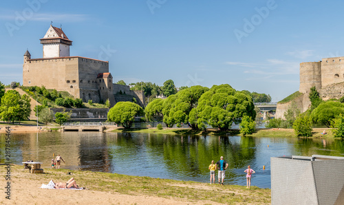 Canvas Print Narva castle or Hermann castle on a sunny day with sunbathers enjoying the sunshine