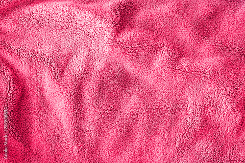 Pink delicate soft background of fur plush smooth fabric. Texture of light red soft fleecy blanket textile. Girly wallpaper