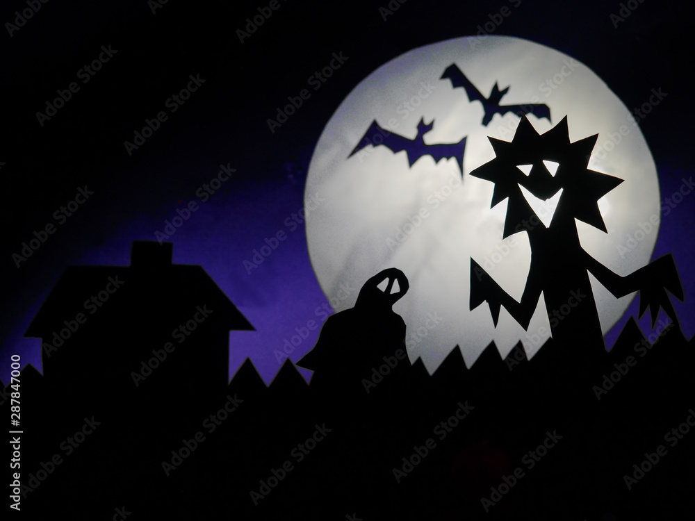 Dark Halloween season background with moon in the background and scary creatures silhouettes. Alien, bats, and funny monster.