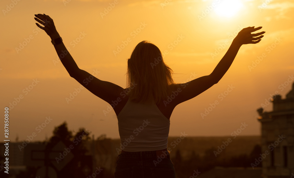Silhouette of free woman enjoying freedom feeling happy at sunset. relaxing woman in pure happiness Silhouette of free woman enjoying freedom feeling happy at sunset. relaxing woman in pure happiness