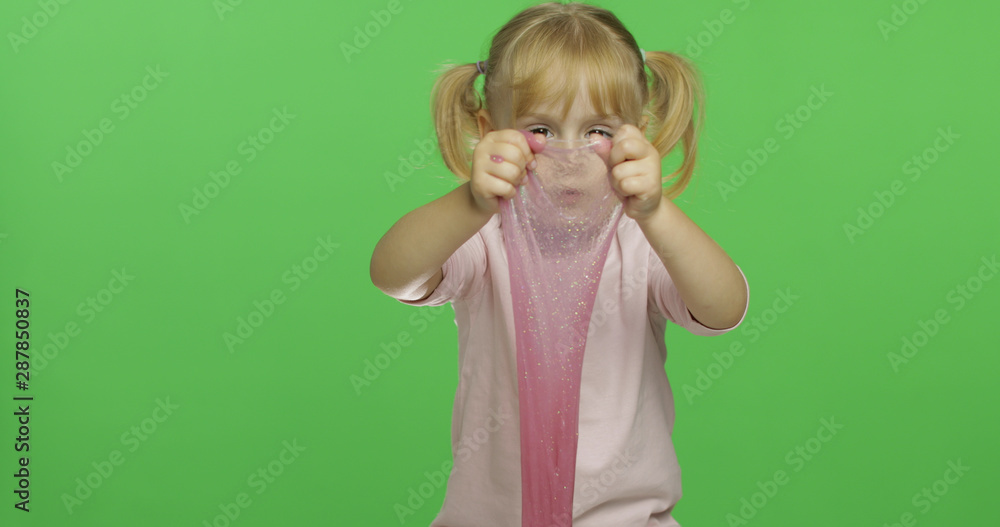 Kid playing with hand made toy slime. Child having fun making pink slime Kid playing with hand made toy slime. Child having fun making pink slime