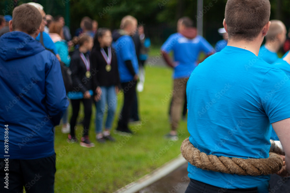 Fototapeta premium Men are holding a conat. Athletes strongman. A huge rope for pulling between rivals. Sports competition for victory.