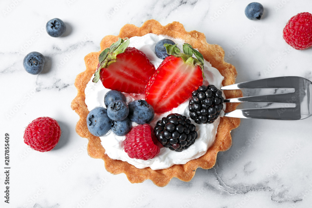 Tart with different berries on marble table, top view. Delicious pastries Tart with different berries on marble table, top view. Delicious pastries