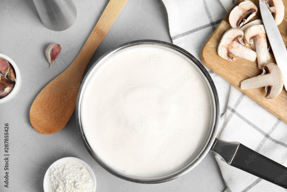 Flat lay composition with delicious creamy sauce on grey table Flat lay composition with delicious creamy sauce on grey table