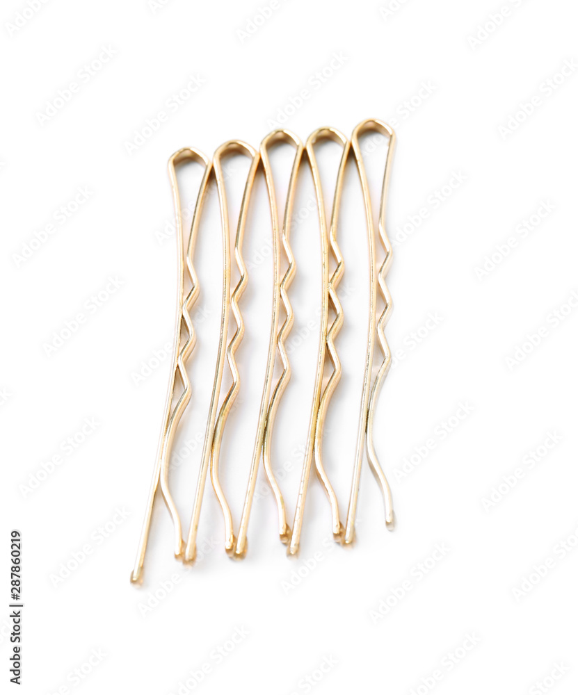 Many gold hair pins on white background, top view Many gold hair pins on white background, top view