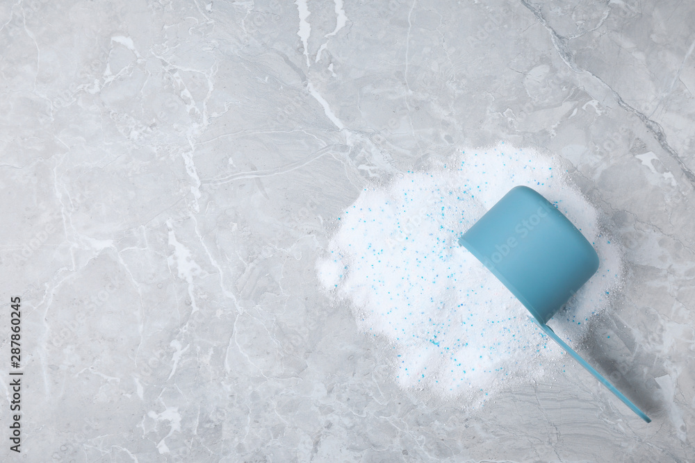 Fototapeta premium Scoop with laundry powder on marble background, top view. Space for text