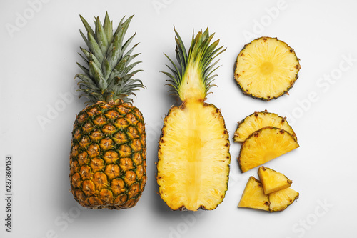 Composition with raw cut pineapples on white background, top view