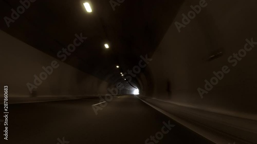 POV, Driving Plate - car driving through a tunnel with bright daylight at the end of it.