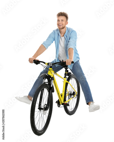Fototapeta Naklejka Na Ścianę i Meble -  Handsome young man riding bicycle on white background