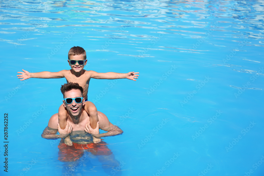 Little boy with father in swimming pool