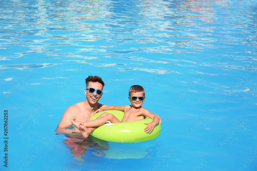 Little boy on inflatable ring with happy father in swimming pool Stock ...