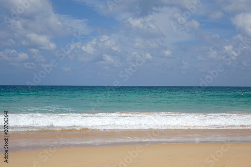 Beautiful seascape in summer season  beach sand  clear sea water blue sky and white clouds. Copy space.