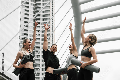 group of caucasian yoga team cheering up team spirit by raise hands up together