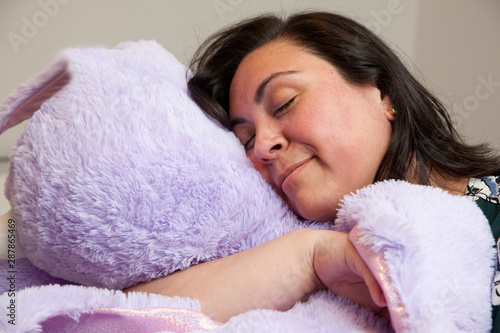 Tablou pe pânză snuggling purple stuffie eyes closed