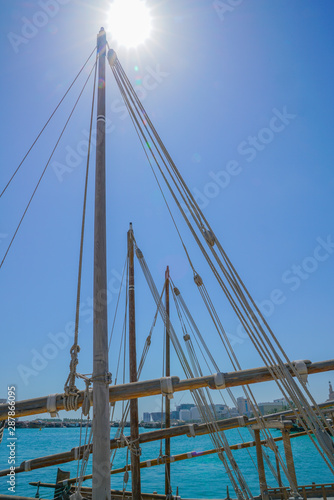 Ropes and spars of traditional rigging of dhow moored along Doha Old Town waterfront.