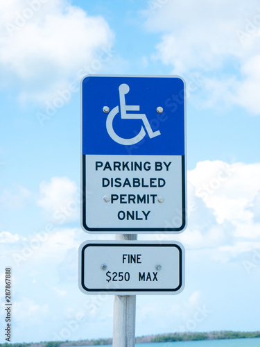 Disabled Parking Permit Sign ($250 Fine) on Blue Sky in the State of Florida.