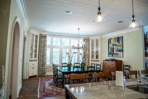 spacious dining room eat in kitchen full of windows and natural light table and chairs and white shiplap ceiling
